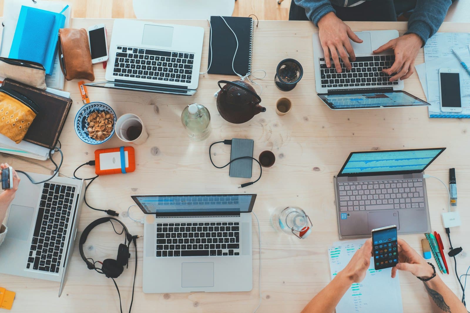 A team working together around a table full of laptops